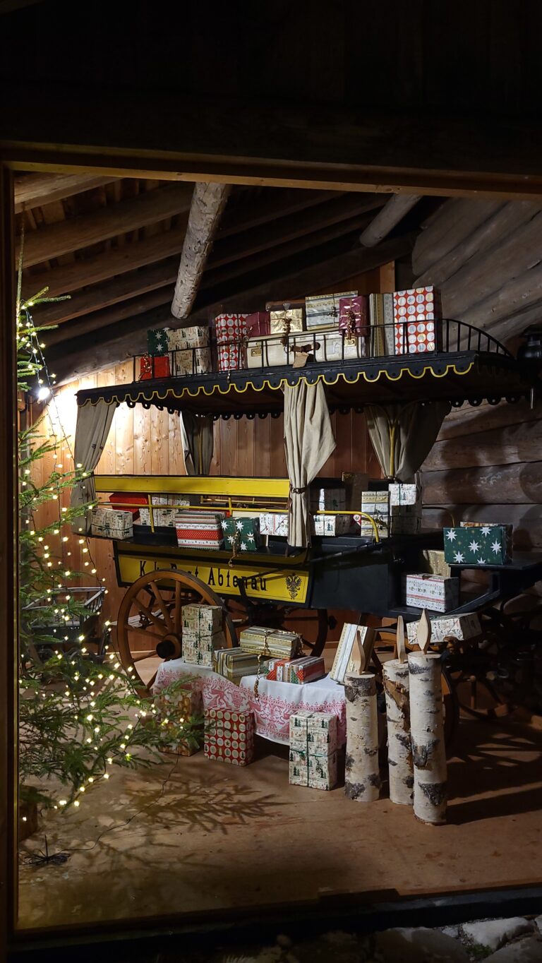 Alte Abtenauer Postkutsche gefüllt mit Geschenken und ein Weihnachtsbaum.